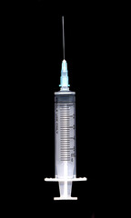 A needle syringe filled with blood like liquid on a black background