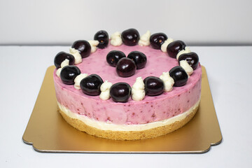Cherry cheesecake on a golden plate.