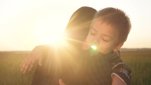 son hugs mom. concept happy family teamwork. boy kid hugs lifestyle beloved mother sunlight at sunset. Womens day concept. parent girl have a tender relationship are in love