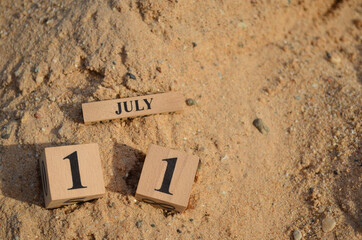 July 11, Number cube with Sand pile for a background.