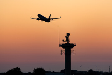 Fototapeta na wymiar Silhouette of a passenger airplane taking off at sunset.