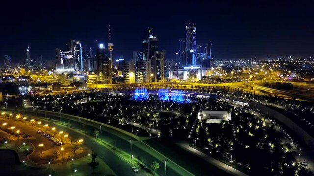 Panoramic view of Kuwait City at Night. Modern Middle East Cityscape Nightlife. Front Dolly Aerial Shot.