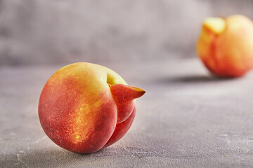 An ugly fruit or vegetable. Strongly ugly peach mutants on a gray background. Ugly fruits are not...