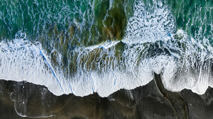 Aerial view ocean on black sand, New Zealand