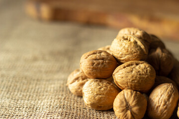 walnuts over jute fabric and a wooden cutting board	