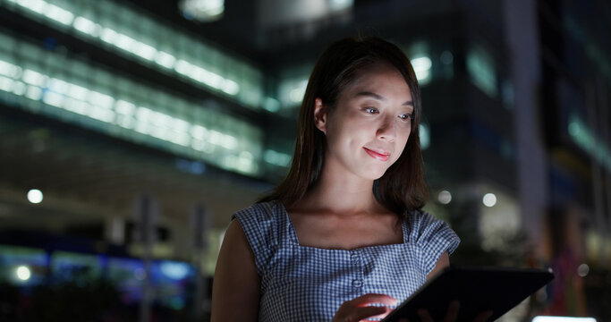 Woman look at tablet computer at outdoor in evening time