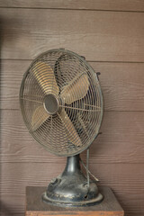 Four-blade antique table fan Made of brass, placed on a wooden table to decorate the house