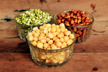 Collection of legumes (chickpeas, green peas, green mung beans, Red Kidney, Dry peas)in different bowls isolated on wooden background.