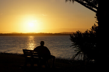 Fototapeta na wymiar Silhouetted man watching a golden sunset.