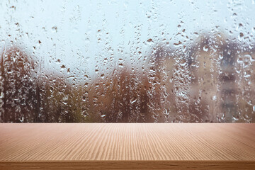 Wooden table near window on rainy day