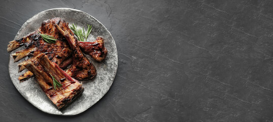 Plate with tasty grilled ribs and space for text on grey table, top view. Banner design