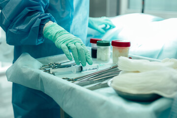 Hand in rubber gloves touching syringe on the table