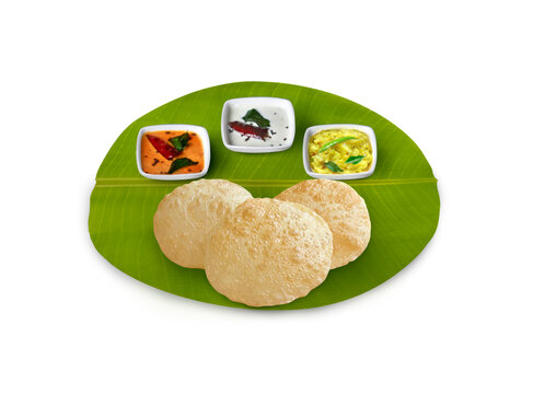 south Indian breakfast poori, poori ,with coconut chutney, potato palaya , and sambar served on banana leaf 