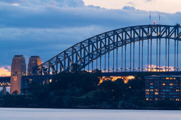 Obraz premium Sydney Harbour Bridge view at dusk with cloudy sky.