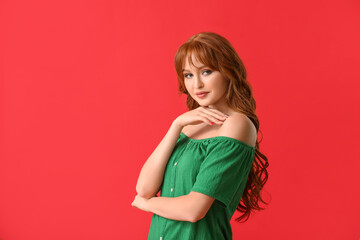 Beautiful young redhead woman on color background