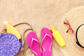 Beach accessories on sand background