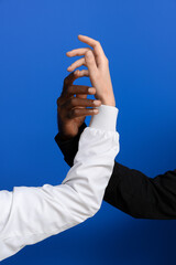 Hands of Caucasian woman and African-American man on color background. Racism concept