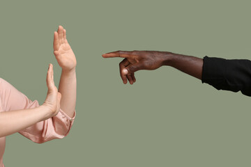 African-American man bulling Caucasian woman on color background. Racism concept