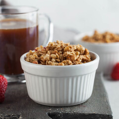 Homemade granola in a white bowl with a Cup of coffee. The concept of a healthy Breakfast. Copy space.