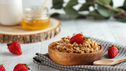 Banner homemade granola in a wooden bowl with strawberries, honey on wooden background. concept of a healthy Breakfast.