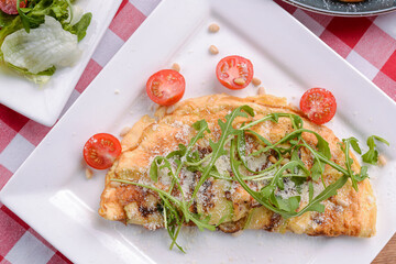 Green asparagus and ham omelet with cherry tomatoes. Selective focus. Italian concept.