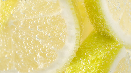 refreshing soda tonic fizzy water, lemon in glass macro close-up. Slice of lemon, mineral bubbles. lemonade
