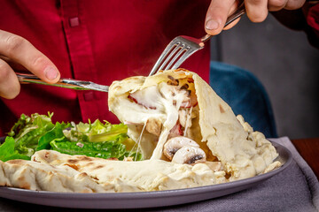 baked calzone. man tastes pizza. closed type of pizza that is folded in half. Delicious homemade food. author menu