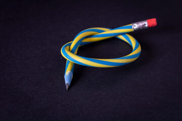 Flexible pencil on a dark background. Selective focus.