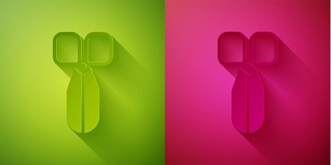 Paper cut Scissors icon isolated on green and pink background. Cutting tool sign. Paper art style. Vector Illustration. © Kostiantyn