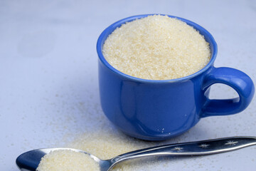 White Sugar in a cup with spoon, diabetes concept