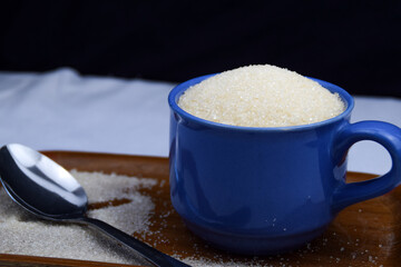 White Sugar in a cup with spoon, diabetes concept
