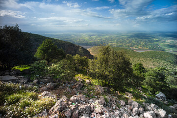 Panoramic view of the fertile valley in the Atlas Mountains in Morocco, Africa. Valleys supplied by irrigation make agriculture possible. In the foreground is rubbish among the rocks