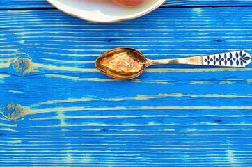 yellow spoon on a wooden blue background