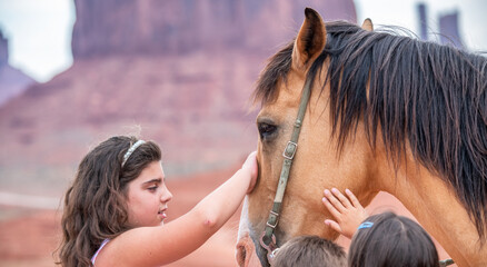 Young girl riding touching horse in the beautiful Monument Valley © jovannig
