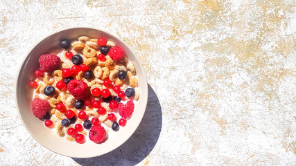bowl of breakfast rings with milk and berries isolated on white background, top view.Delicious corn rings with berries on table.Healthy breakfast ,cereal rings in bowl with milk, honey, berries