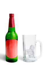 Alcoholic drink bottle and empty glass with ice cubes