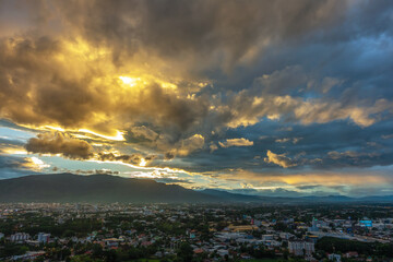 Dramatic sunrise or sunset sky and clouds moving over the mountain and city, Chiang Mai in Thailand.