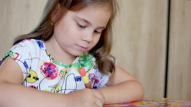 Happy little girl or cute primary child school child painting or writening on paper. Children elementary education concept.
