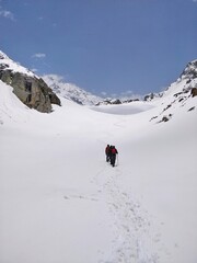Manali, India - June 14th 2019: A group of friends/hikers in a club climbing a narrow Snowy/Glacial valley to reach the Goal/top of the Indian Himalayan Mountain Peak. 
Hampta Pass trek near Manali.