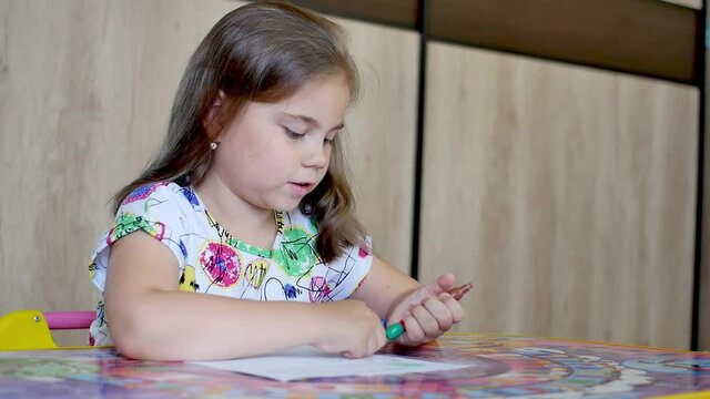 Happy little girl or cute primary child school child painting or writening on paper. Children elementary education concept.