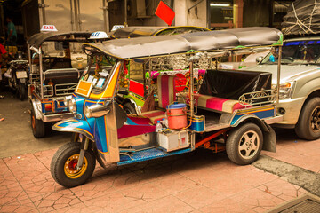 Bangkok, Thailand | December 14, 2019: View of popular tuk tuk taxis awaiting customers in Bangkok, Thailand.
