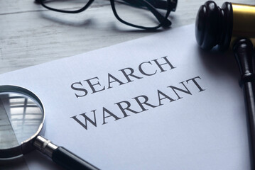 Selective focus of magnifying glass,gavel,glasses and paper written with Search Warrant on white...