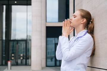 A woman doctor in uniform has stress and prayer during an outbreak