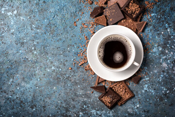 Cup of black coffee with pieces of tasty milk and dark chocolate