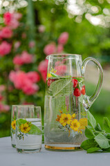 In the summer garden of a country house. Have a nice summer weekend, relax. Soft drink (lemonade) with mint and mint leaves, a healthy product