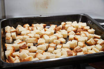 Square toasted pieces of homemade delicious rusk, hardtack, Dryasdust, zwieback on a baking sheet.