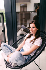 Charming woman rests on her balcony lying on a chair during a quarantine in Europe