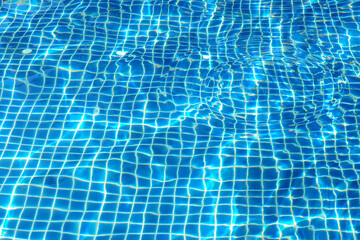Ripples in the pool that reflect the sun Water surface details Is a bright blue background