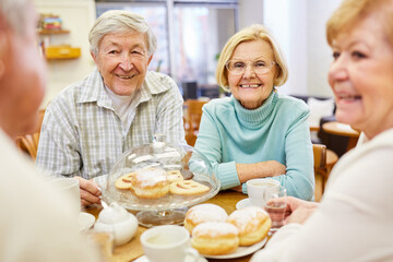 Fröhliche Senioren beim Kaffee trinken und Kuchen essen zusammen im Altersheim