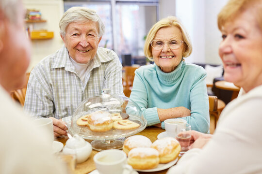 Fr&ouml;hliche Senioren beim Kaffee trinken und Kuchen essen zusammen im Altersheim